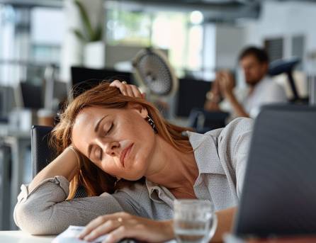Bild Zeit Frau müde in einem Büro mit schlechter und warmer Luft.